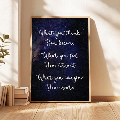 A framed inspirational quote print leaning against a beige wall on a wooden floor, next to stacked books and a plant. The print features the quote 'What you think.