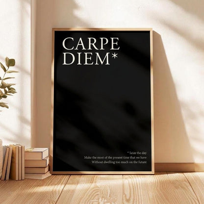 A framed black poster leaning against a beige wall on a wooden floor, with the words 'CARPE DIEM*' in large white serif text and a small quote below. The scene includes warm sunlight, leaf shadows, books, and a plant.