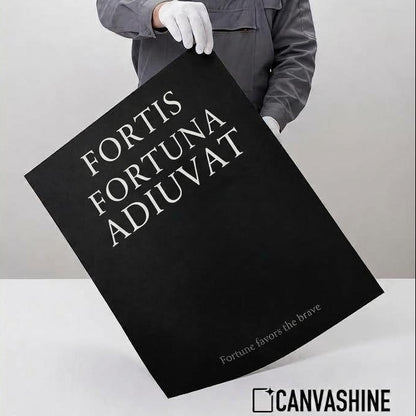 A person in a gray work jacket and white gloves holds a large black poster with white text reading 'FORTIS FORTUNA ADIUVAT' against a light gray studio background. The left side features a beige panel with text describing professional giclée quality, including archival paper, pigment ink, matte finish, and long-lasting design.