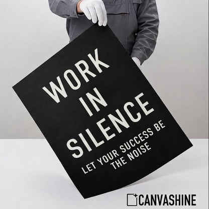 A person in a gray work jacket and white gloves holds a large black poster with white text that reads, 'IF YOU ARE NOT WILLING TO LEARN NO ONE CAN HELP YOU. IF YOU ARE DETERMINED TO LEARN NO ONE CAN STOP YOU.