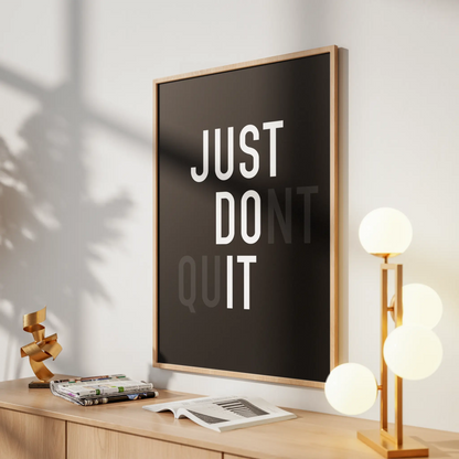 Framed poster with 'JUST DO IT' text on a wall above a desk with decor items.