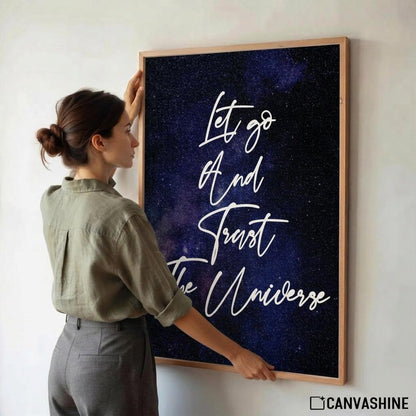 Poster featuring a dark blue and purple galaxy background with white script text that reads 'Let go And Trust The Universe'.