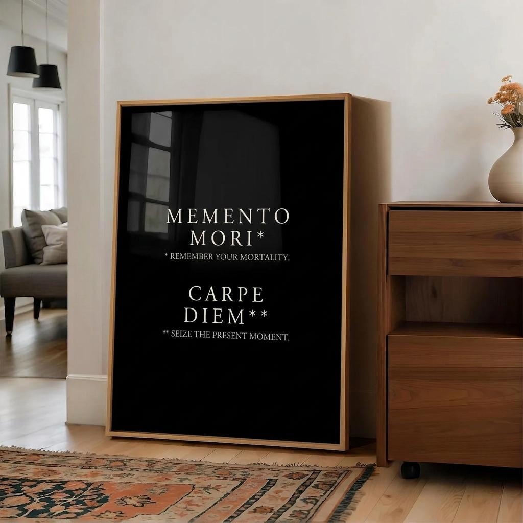 A black framed wall art print with white Latin text reading 'MEMENTO MORI' and 'CARPE DIEM' stands in a modern living room next to a wooden cabinet.